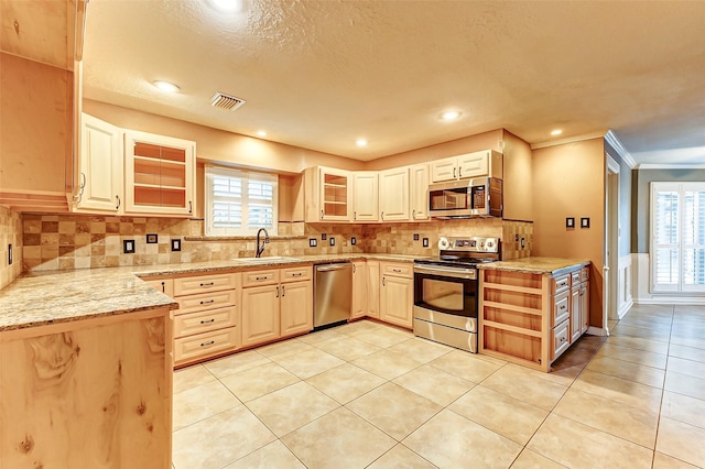 kitchen featuring light tile patterned floors, tasteful backsplash, visible vents, appliances with stainless steel finishes, and a sink