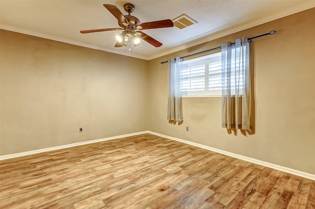 empty room featuring a ceiling fan, light wood-style flooring, baseboards, and crown molding