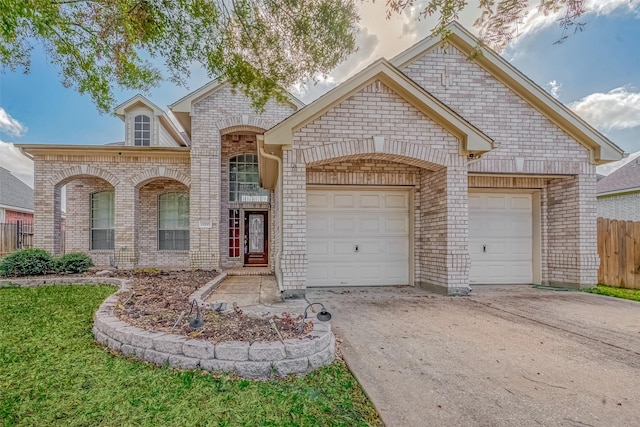 french country inspired facade featuring driveway, brick siding, an attached garage, and fence