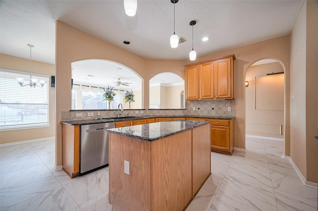 kitchen featuring a sink, arched walkways, stainless steel dishwasher, and marble finish floor