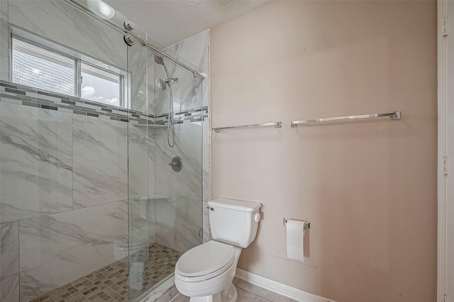 bathroom featuring a shower stall, toilet, and baseboards