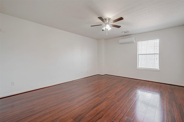 unfurnished room featuring visible vents, a wall mounted AC, a textured ceiling, ceiling fan, and dark wood-style flooring