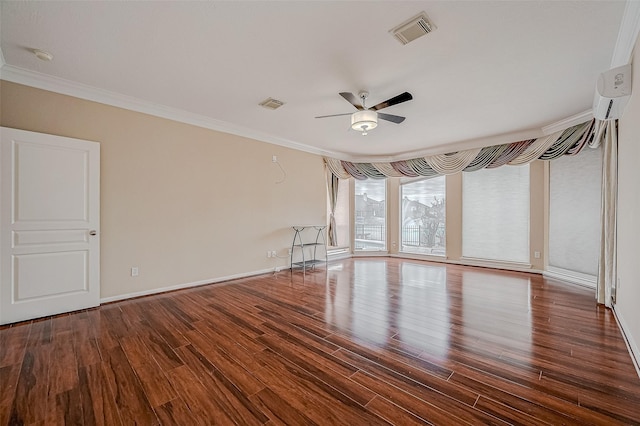 spare room with wood finished floors, a ceiling fan, visible vents, and ornamental molding