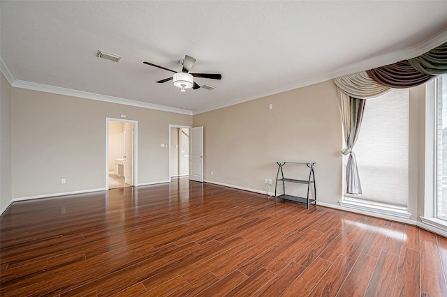 empty room featuring visible vents, crown molding, ceiling fan, and wood finished floors