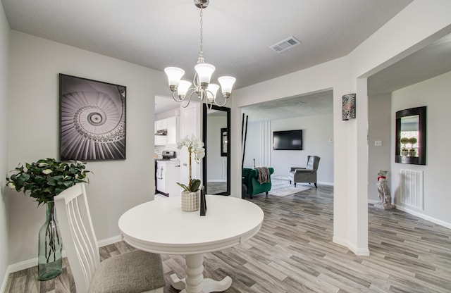 dining room with visible vents, light wood-style flooring, and baseboards