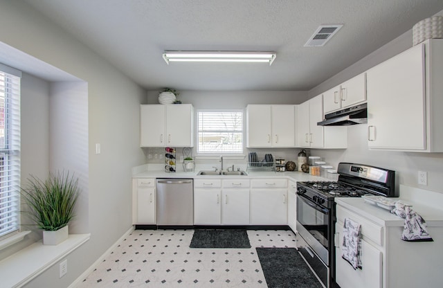 kitchen with light floors, stainless steel appliances, visible vents, a sink, and under cabinet range hood