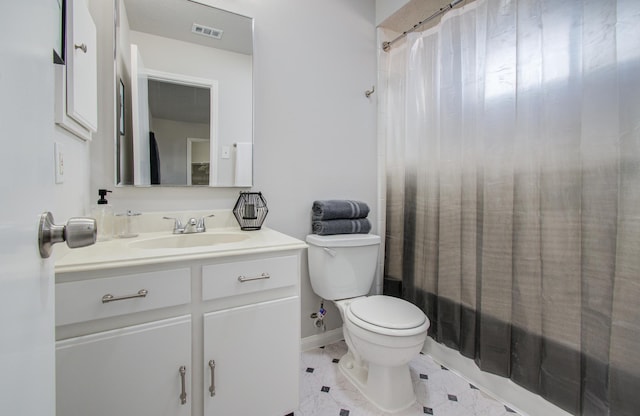 bathroom featuring toilet, vanity, visible vents, and baseboards