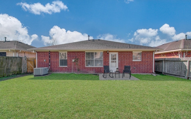 rear view of property with a patio area, brick siding, a lawn, and a fenced backyard