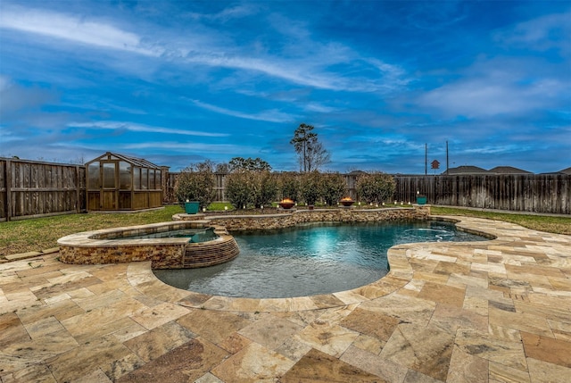 view of swimming pool with a patio area, a pool with connected hot tub, and a fenced backyard