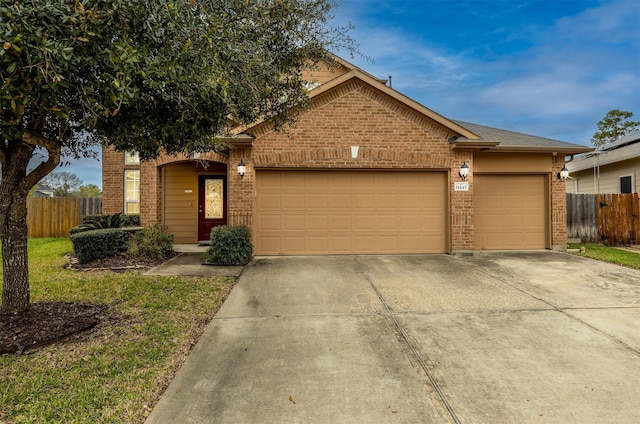 ranch-style home with concrete driveway, an attached garage, fence, and brick siding