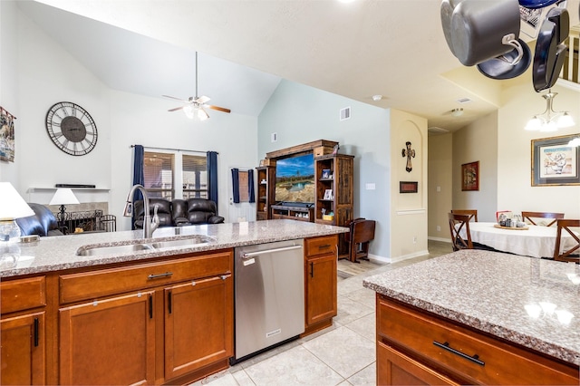 kitchen featuring brown cabinets, a sink, stainless steel dishwasher, open floor plan, and lofted ceiling