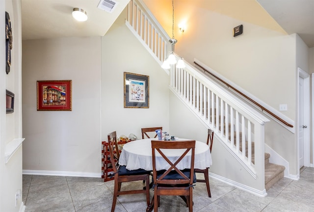 dining area featuring tile patterned floors, visible vents, baseboards, and stairs