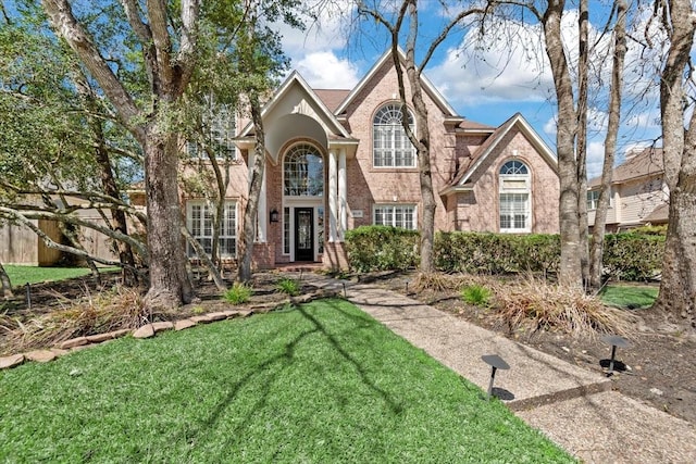 view of front of house featuring a front lawn and brick siding