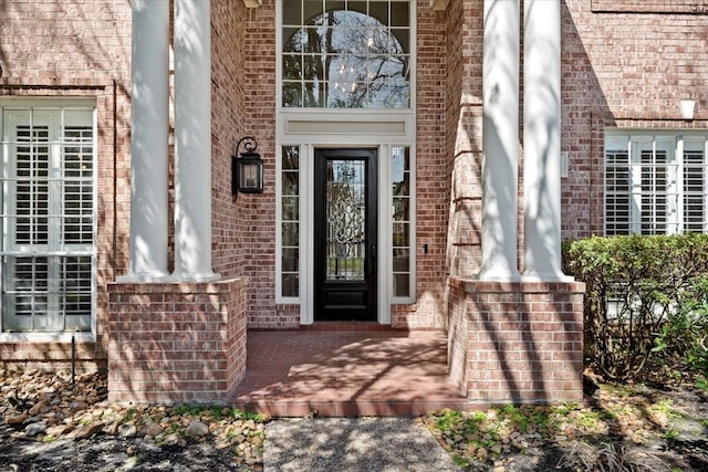 entrance to property featuring brick siding