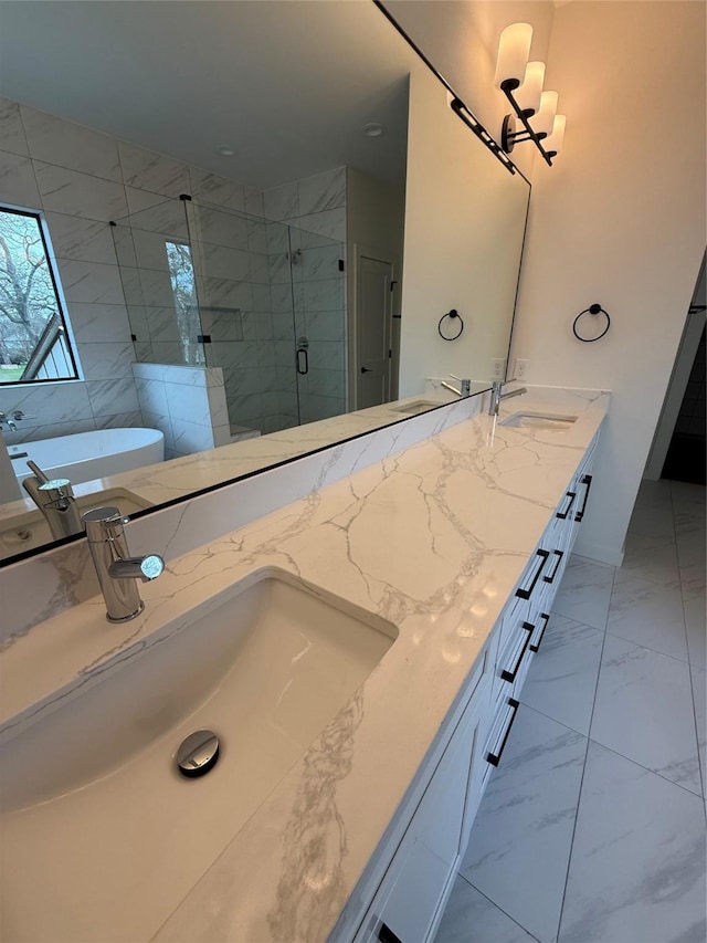 full bathroom featuring double vanity, marble finish floor, a shower stall, and a sink