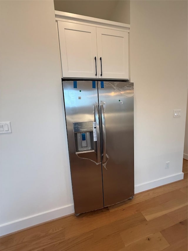 kitchen featuring light wood-style flooring, white cabinetry, baseboards, and stainless steel fridge with ice dispenser