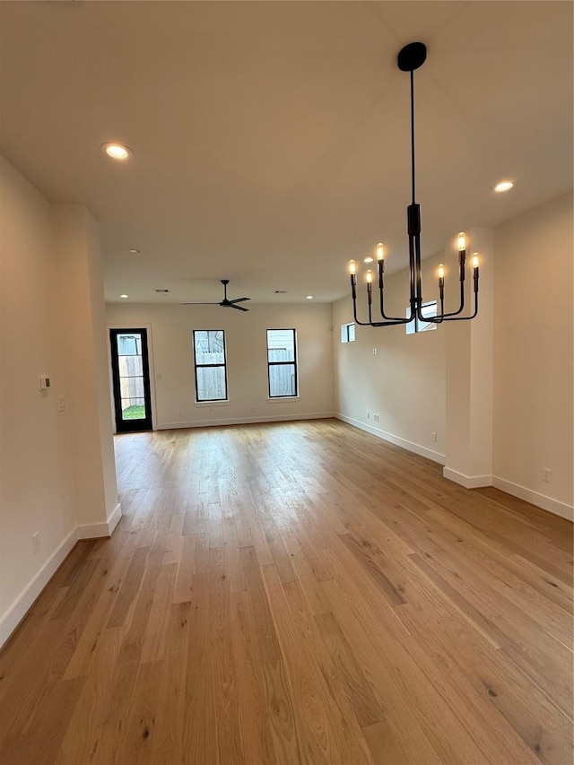 interior space featuring ceiling fan with notable chandelier, light wood finished floors, recessed lighting, and baseboards