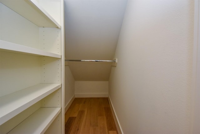 walk in closet with light wood-style floors