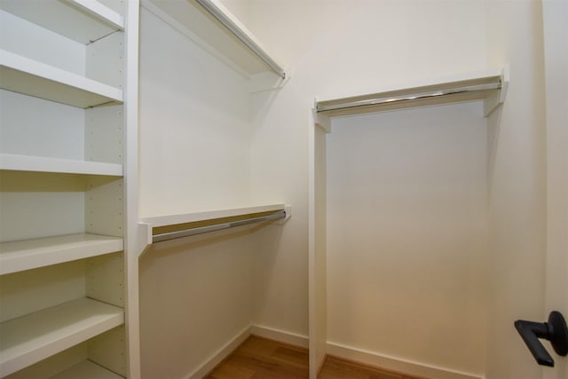 walk in closet with wood finished floors