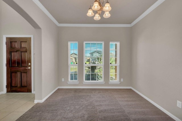 spare room with arched walkways, light tile patterned flooring, baseboards, and crown molding