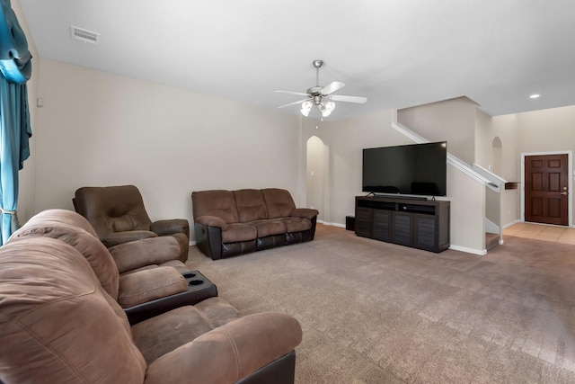 living area featuring carpet floors, arched walkways, and visible vents