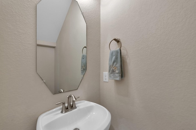 bathroom with a textured wall and a sink