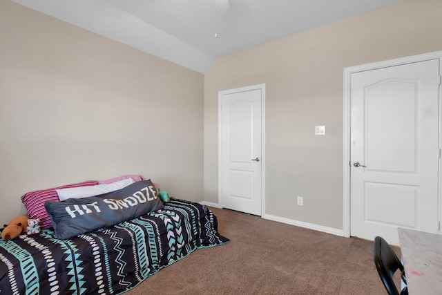 carpeted bedroom with vaulted ceiling and baseboards