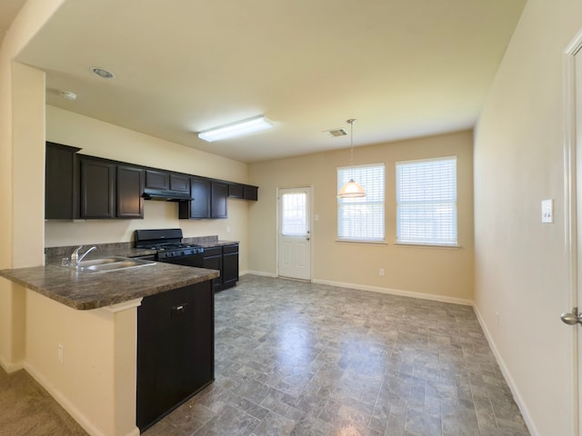 kitchen with black gas range, a sink, visible vents, baseboards, and dark countertops