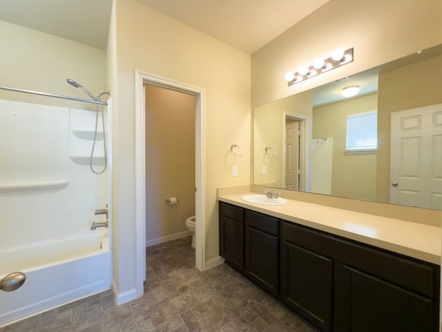 bathroom with shower / bathtub combination, toilet, vanity, baseboards, and stone finish flooring