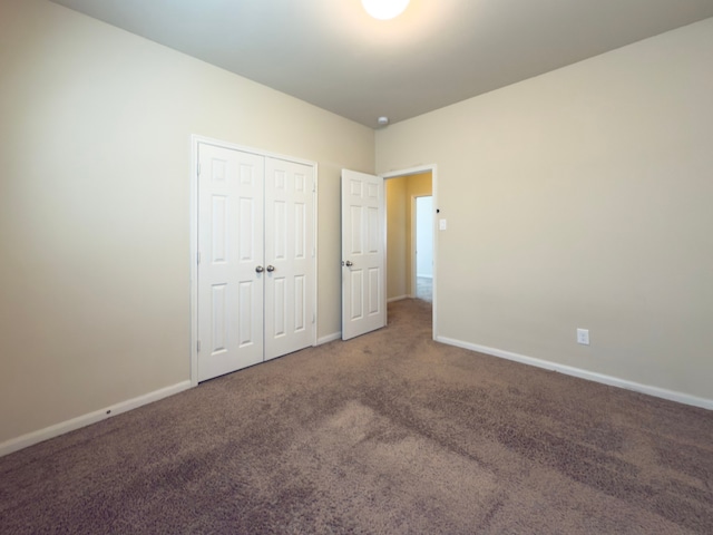 unfurnished bedroom featuring carpet floors, a closet, and baseboards