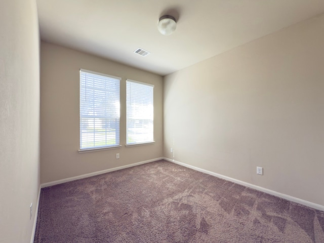 carpeted empty room with visible vents and baseboards