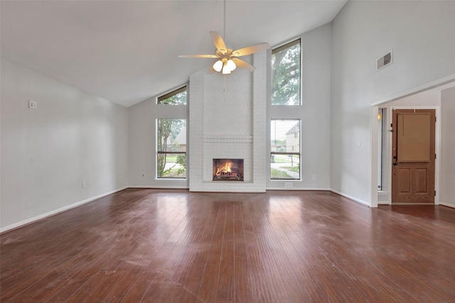 unfurnished living room featuring plenty of natural light, hardwood / wood-style flooring, a fireplace, and visible vents