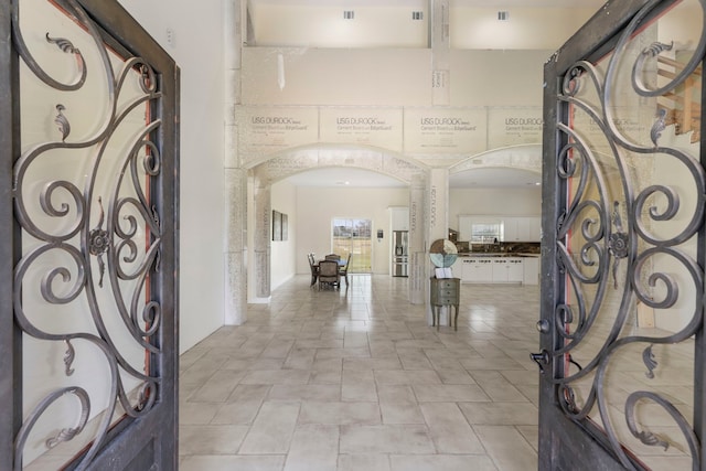 entryway featuring a towering ceiling and arched walkways