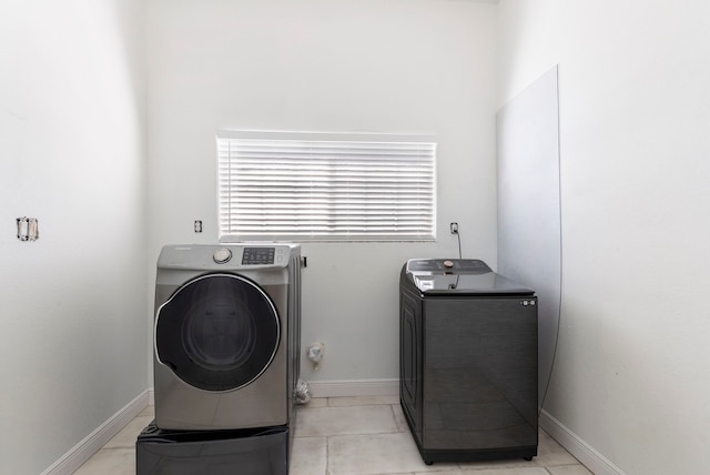 clothes washing area featuring washer / dryer, laundry area, and baseboards