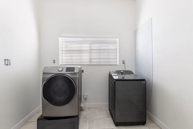 2464 N Walker Rd, Cleveland, TX 77328 - laundry room featuring washer / dryer, baseboards, and light tile patterned flooring