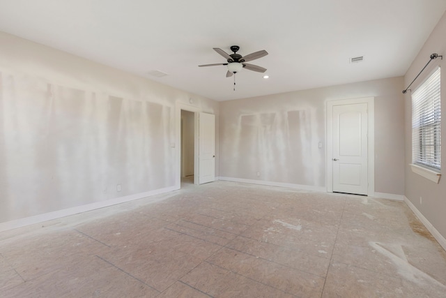 spare room featuring baseboards, visible vents, and ceiling fan