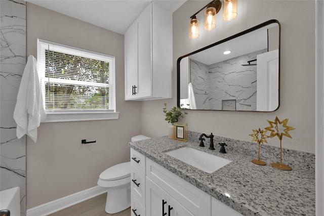 full bathroom featuring a marble finish shower, baseboards, toilet, wood finished floors, and vanity