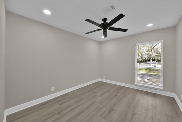 unfurnished room with ceiling fan, recessed lighting, wood finished floors, visible vents, and baseboards