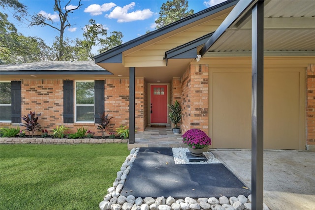 property entrance featuring brick siding and a lawn