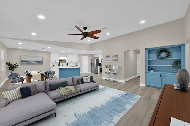 living room featuring recessed lighting, visible vents, light wood-style flooring, and baseboards