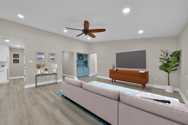 living room with recessed lighting, light wood-style flooring, and baseboards