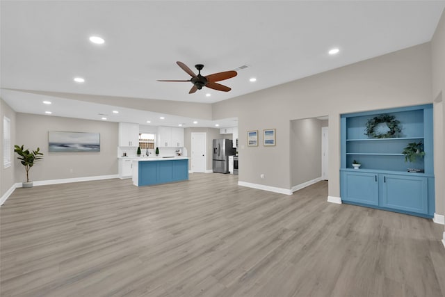 unfurnished living room featuring light wood-type flooring, ceiling fan, baseboards, and recessed lighting