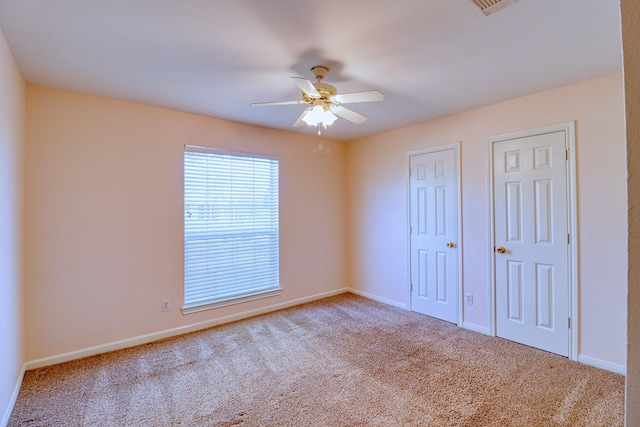 unfurnished bedroom with carpet flooring, a ceiling fan, and baseboards