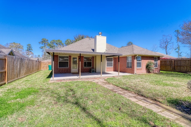 back of property featuring a patio, brick siding, a fenced backyard, and a chimney