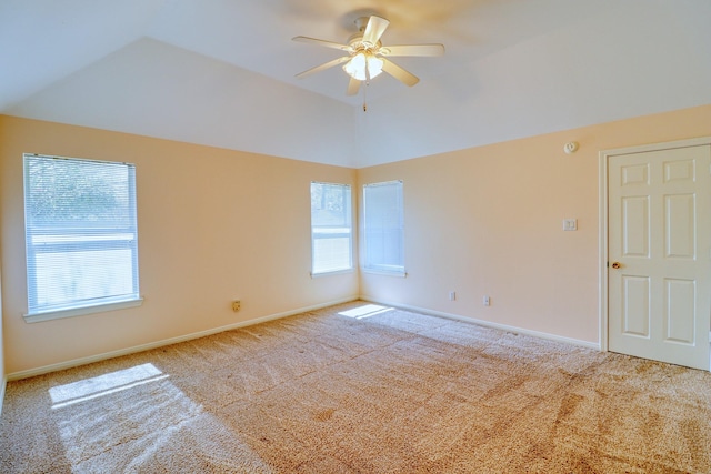 carpeted spare room featuring plenty of natural light, baseboards, a ceiling fan, and vaulted ceiling