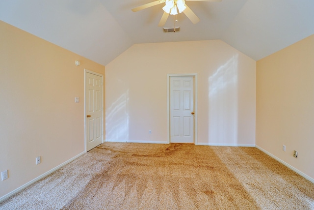 carpeted empty room with visible vents, baseboards, a ceiling fan, and vaulted ceiling