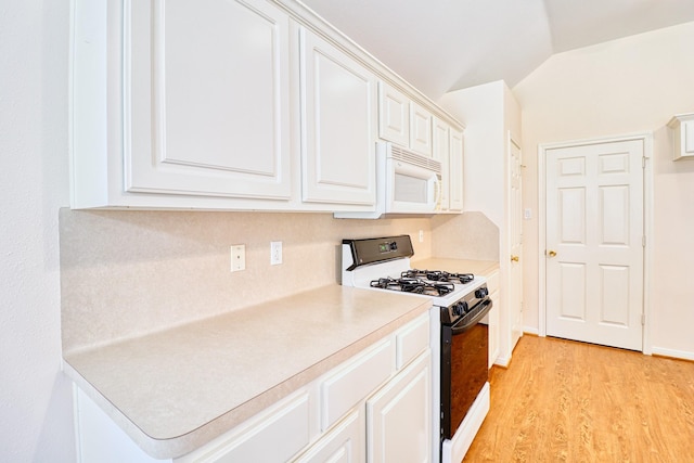 kitchen with light countertops, vaulted ceiling, light wood-style floors, white cabinets, and white appliances