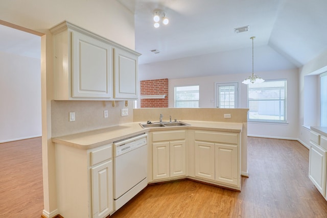 kitchen featuring visible vents, a peninsula, a sink, light countertops, and dishwasher