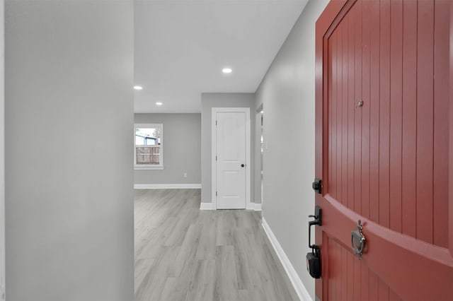 corridor featuring recessed lighting, light wood-style flooring, and baseboards