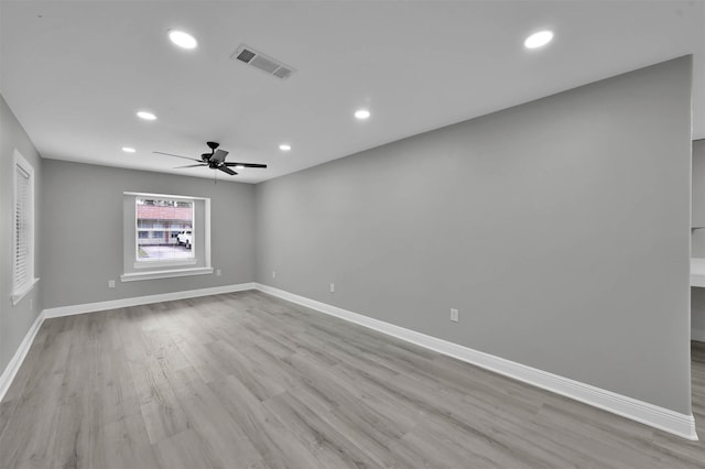 spare room featuring recessed lighting, wood finished floors, visible vents, and baseboards